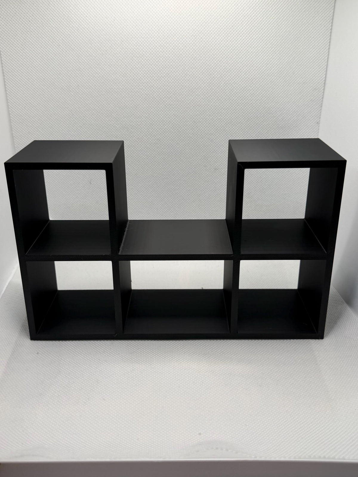 Empty black mini record holder showing five record slots and the center player bay